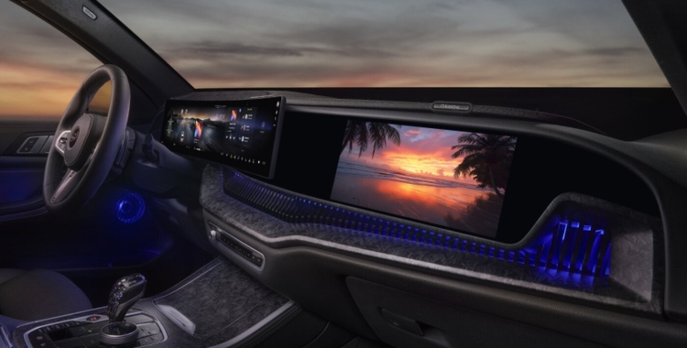 HARMAN Ready Display automotive dashboard screens showing a vivid sunset beach scene, mounted in a vehicle interior at dusk